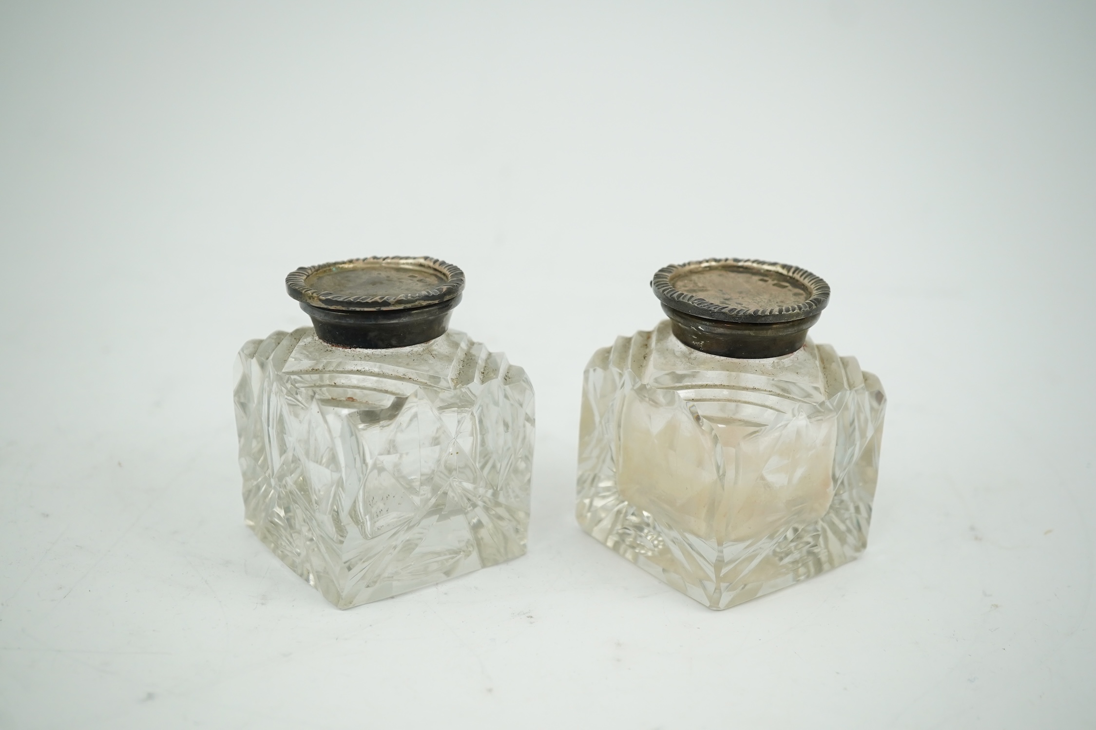 A pair of silver mounted cut glass inkwells, maker JT, height 66mm. Condition - fair to good